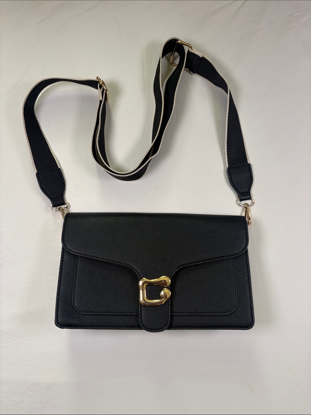 Classic Black Crossbody Bag with Gold Buckle and Striped Strap